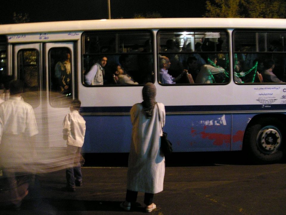 Woman in hijab waiting for a bus in Tehran